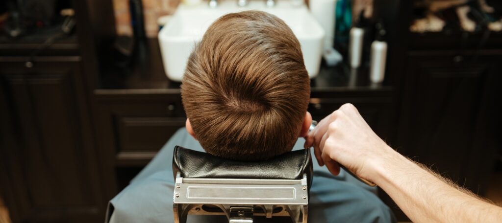 a man is getting his hair cut by a barber