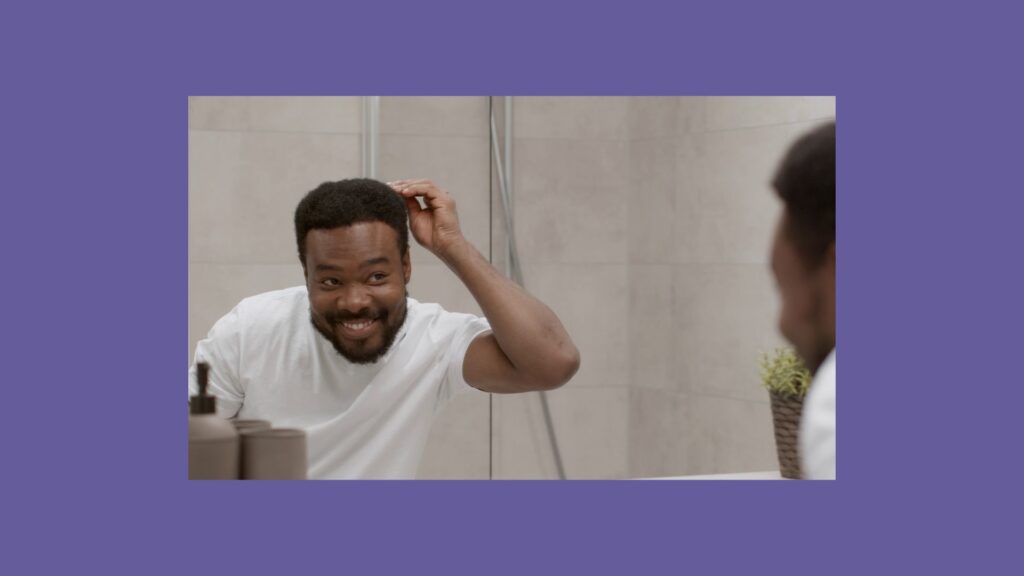 a man in a white shirt is brushing his hair in front of a mirror