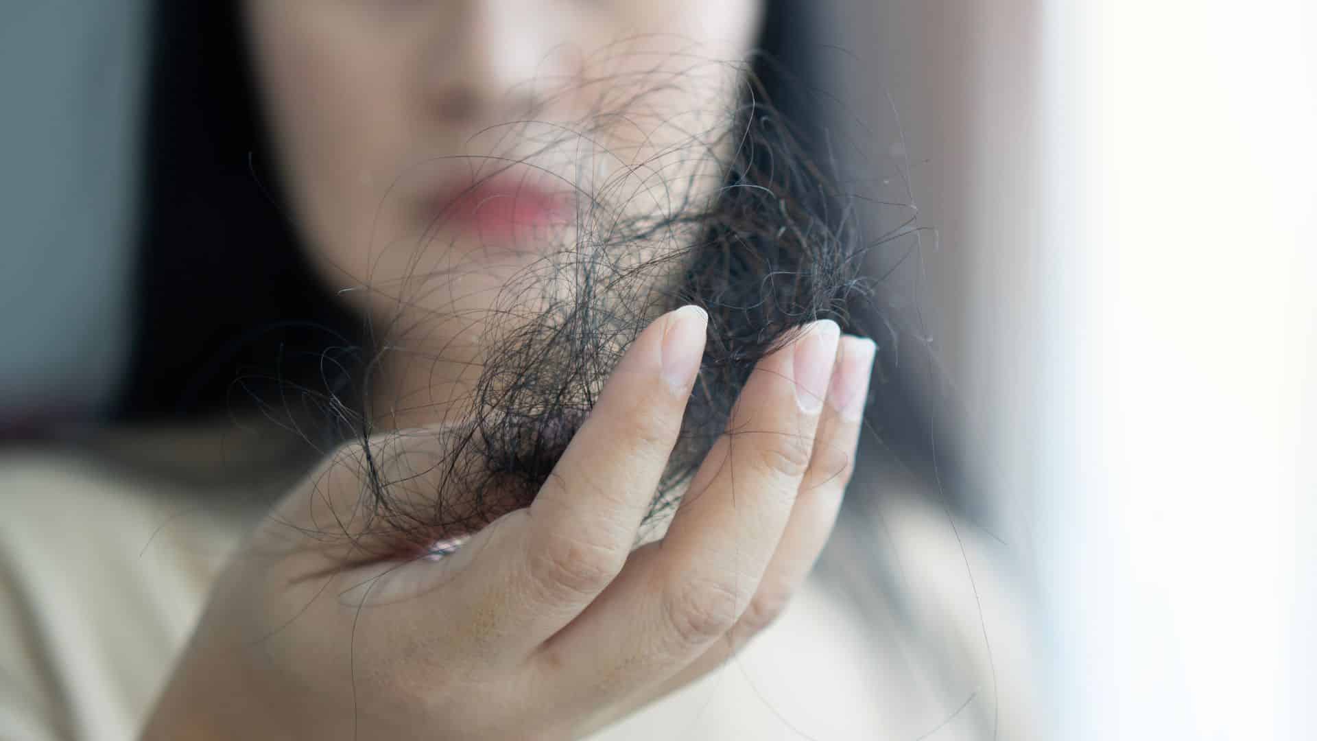 a woman is holding a bunch of hair in her hand